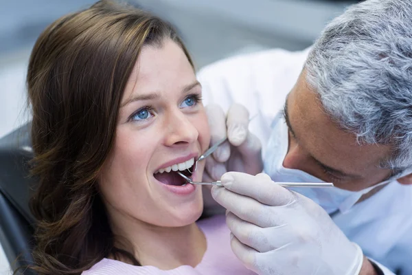 歯科用具を持つ女性患者を調べる — ストック写真