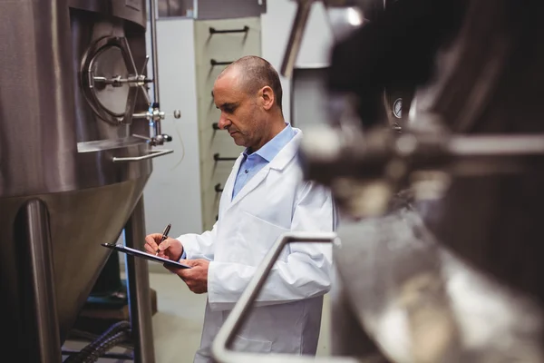 Fabricant debout près des réservoirs de stockage à la brasserie — Photo