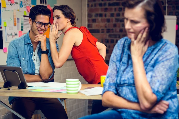 Businesswoman in deep thought and colleagues whispering in backg — Stock Photo, Image