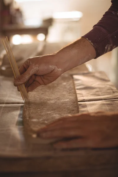 Potier mâle concevant de l'argile avec des bâtons — Photo