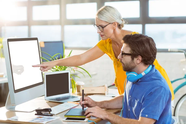 Diseñadores gráficos interactuando mientras trabajan en la computadora — Foto de Stock