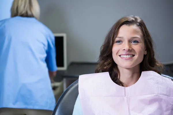 Улыбающийся пациент сидит на стуле стоматолога — стоковое фото