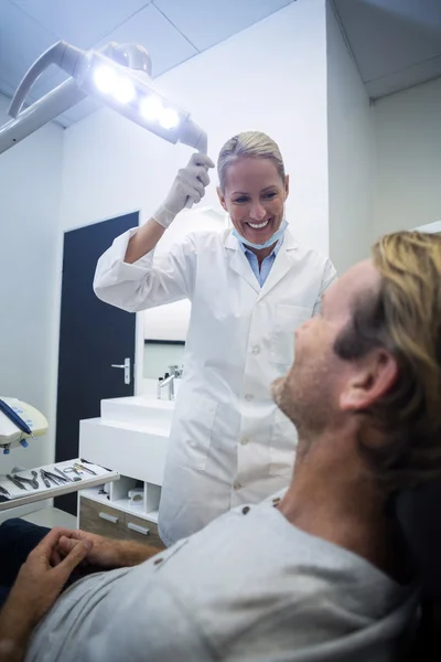 Odontologista interagindo com paciente do sexo masculino — Fotografia de Stock