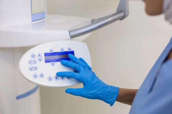 Dental assistant adjusting x-ray equipment — Stock Photo, Image