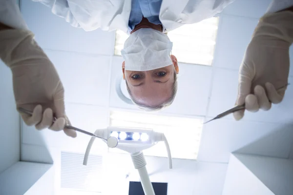 Dentista feminina segurando ferramentas dentárias — Fotografia de Stock