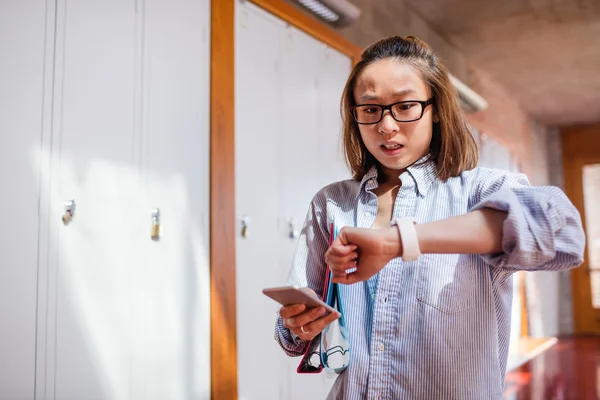 Jonge vrouw tijd tijdens het gebruik van mobiele telefoon controleren — Stockfoto