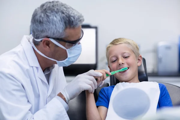 年轻患者刷牙的牙医 — 图库照片