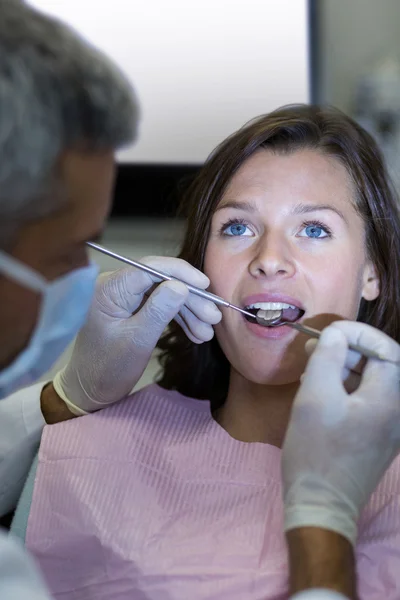 Zahnarzt untersucht Patientin mit Werkzeug — Stockfoto