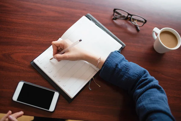 Vrouw die in dagboek schrijft — Stockfoto