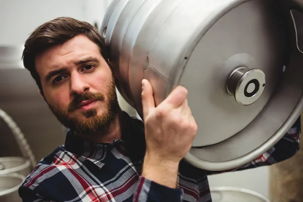Jovem fabricante carregando barril na cervejaria — Fotografia de Stock
