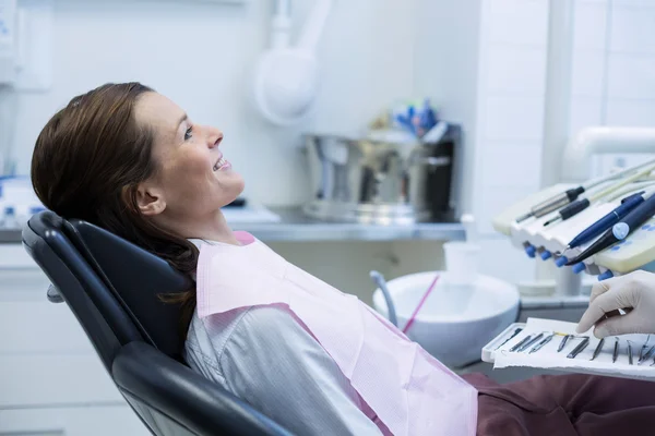 Dentista recogiendo herramientas dentales para examinar a una paciente femenina —  Fotos de Stock