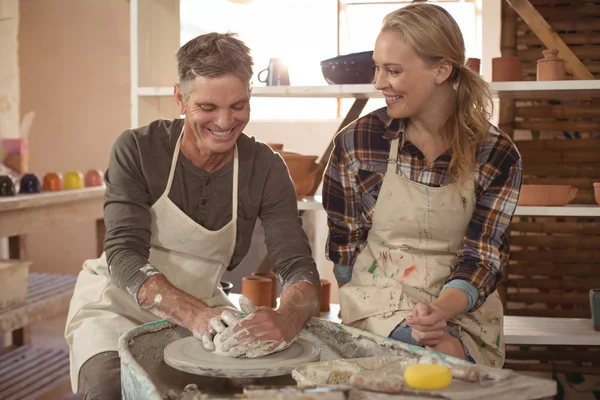 Male potter assisting female potter — Stock Photo, Image