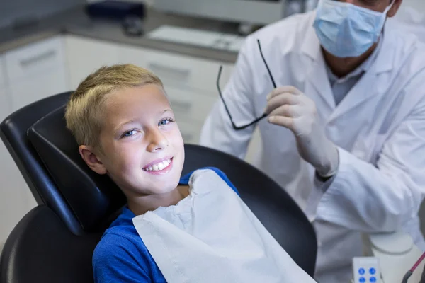 Jovem paciente sorridente sentado na cadeira do dentista — Fotografia de Stock