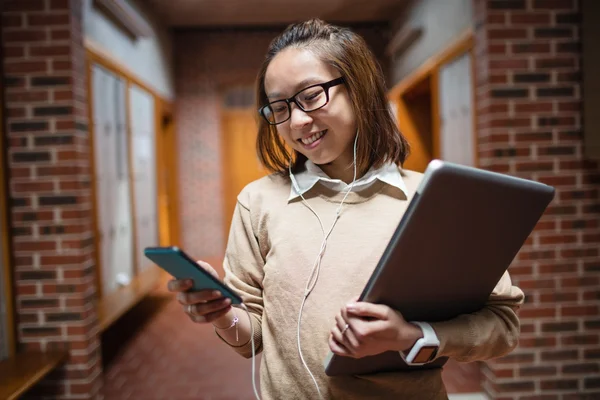 Fiatal nő használ mozgatható telefon-ban folyosó — Stock Fotó