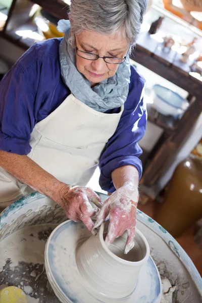 Attentive female potter making pot — Stock Photo, Image