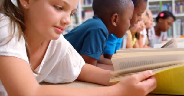 Niños de la escuela leyendo libro en la biblioteca — Vídeo de stock