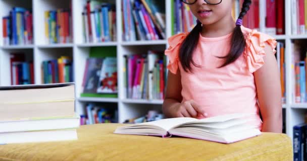 Okul kütüphanesinde kız öğrenci okuma kitabı — Stok video
