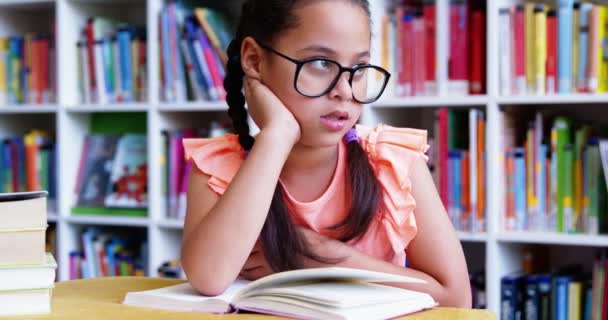 Doordachte schoolmeisje zittend op tafel — Stockvideo