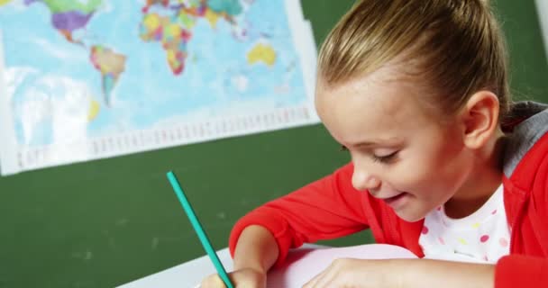 Skolflicka gör läxor i klassrummet — Stockvideo