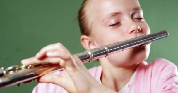 Schoolgirl playing flute in classroom — Stock Video