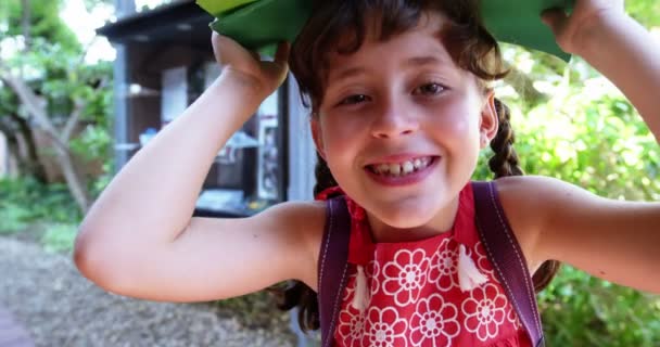 Schülerin trägt Bücher über Kopf in der Schule — Stockvideo