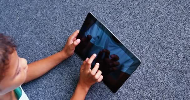 Schüler liegt auf dem Boden und benutzt Tablet — Stockvideo