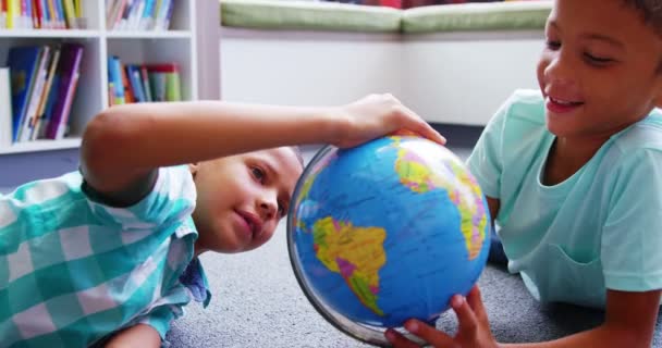 Schoolkids titta på världen i biblioteket i skolan — Stockvideo