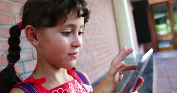 Schoolmeisje met behulp van Tablet PC in gang op school — Stockvideo