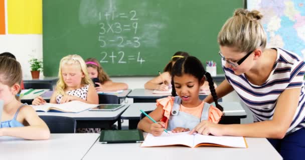 Profesor ayudando a colegiala con su tarea — Vídeo de stock