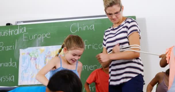 Çocuklar öğretmen üzerinde kağıt top atma — Stok video