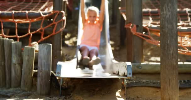 Schoolgirl sliding on slide in school playground — Stock Video