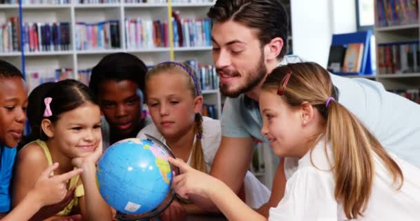Δάσκαλος συζητά υδρόγειο με παιδιά στη βιβλιοθήκη — Αρχείο Βίντεο