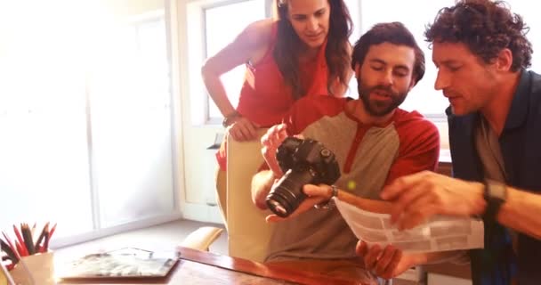 Ontwerpers houden digitale camera en praten — Stockvideo