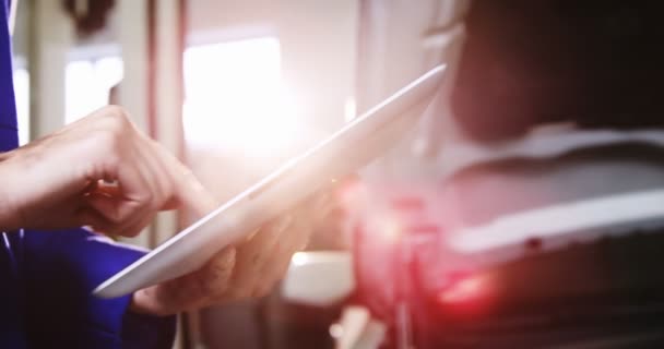 Mechanic using tablet while checking car — Stock Video