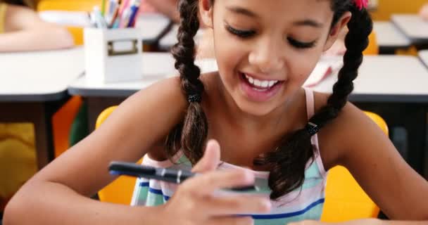 Colegiala escribiendo en chit en el aula — Vídeos de Stock