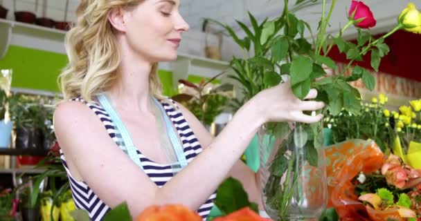 Fiorista che organizza rose in vaso di fiori — Video Stock