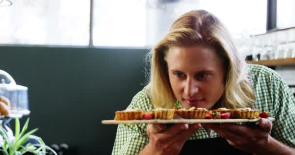 Garçom cheirando uma bandeja de cupcakes — Vídeo de Stock