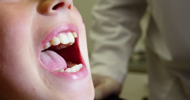 Zahnarzt untersucht eine junge Patientin — Stockvideo