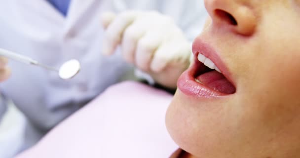 Dentista examinando uma paciente do sexo feminino — Vídeo de Stock