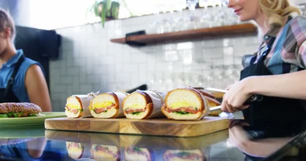 Serveerster inrichtend lange kaas hamburger — Stockvideo