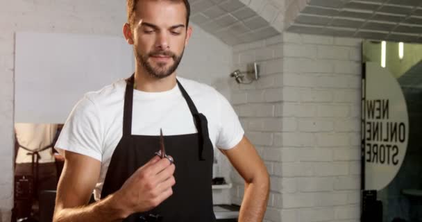 Peluquero masculino mirando tijera — Vídeo de stock