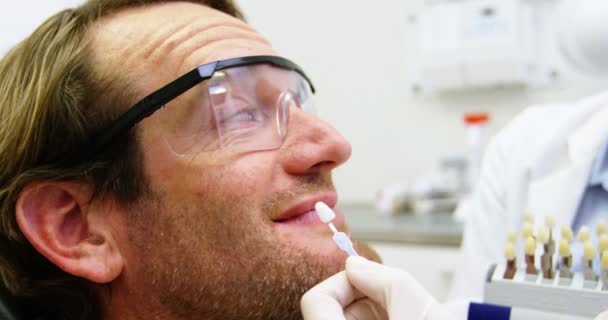 Dentiste montrant des nuances de dents au patient masculin — Video