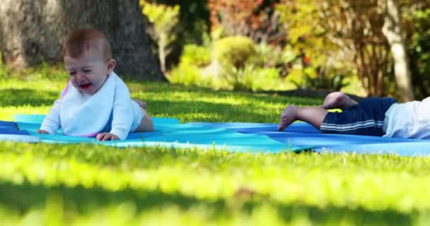 Deux bébés couchés sur un tapis d'exercice — Video