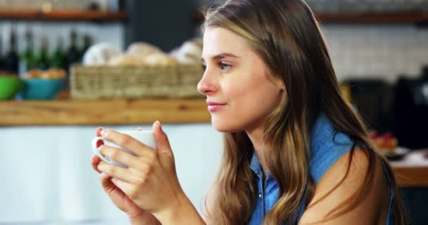 Женщина пьет кофе в столовой — стоковое видео