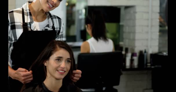 Женщина-парикмахер работает на клиента — стоковое видео