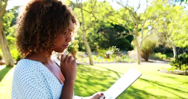 Mujer usando tableta en el parque — Vídeos de Stock