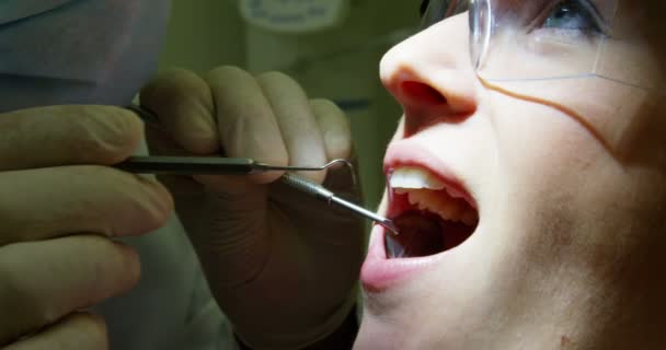 Dentista examinando uma paciente do sexo feminino — Vídeo de Stock