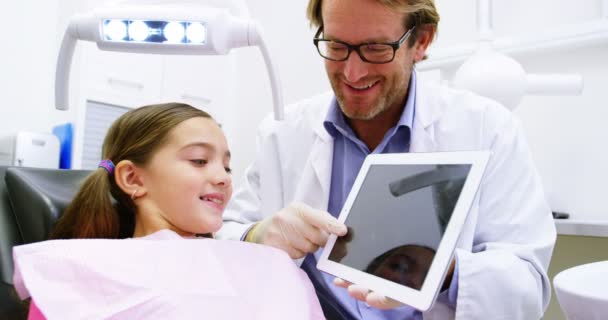 Dentista mostrando tablet digital para o paciente — Vídeo de Stock