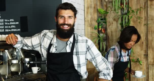 Чоловік офіціант посміхається в кафетерії — стокове відео