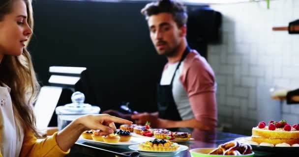 Клієнт вибирає десерт за лічильником — стокове відео